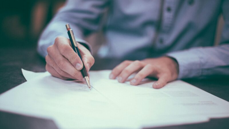 Executive signing a software contract at a desk