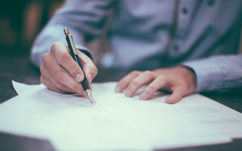 Executive signing a software contract at a desk