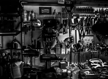 Metal hand tools arranged on a workshop wall in grayscale