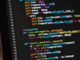 Close view of a laptop screen showing lines of code in a dark editor