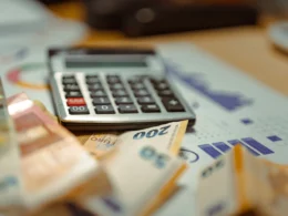A calculator sitting on top of a pile of money