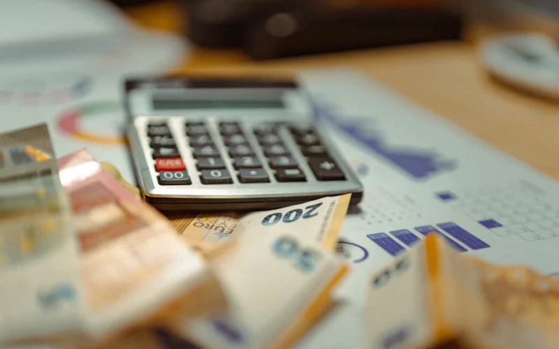 A calculator sitting on top of a pile of money