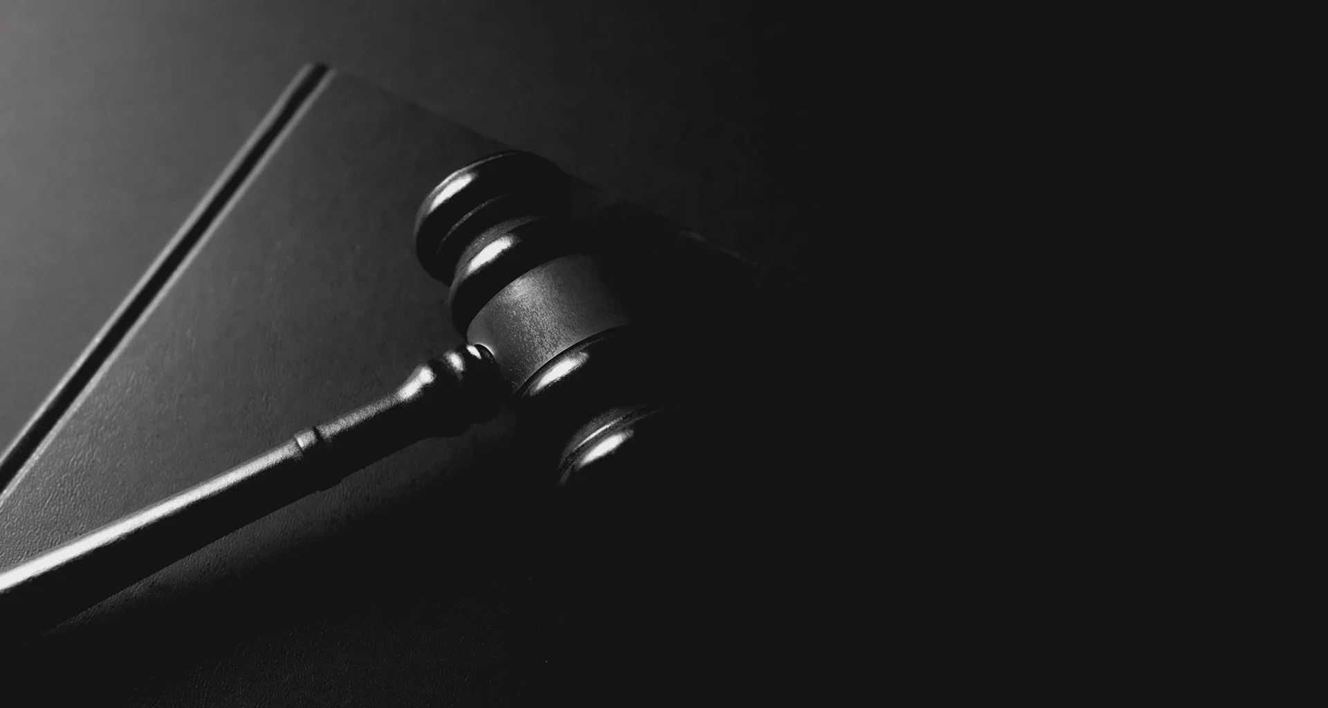 A gavel rests on a dark background.