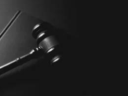 A gavel rests on a dark background