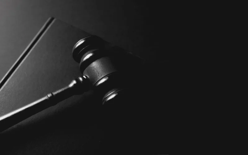 A gavel rests on a dark background
