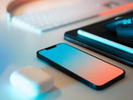A mouse, keyboard, and cell phone sitting on a desk
