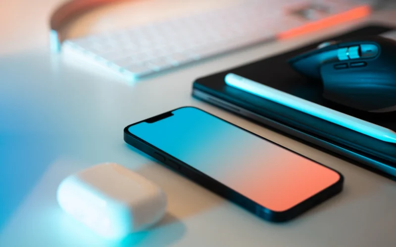 A mouse, keyboard, and cell phone sitting on a desk