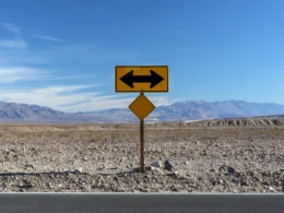 A road sign pointing in opposite directions in the desert