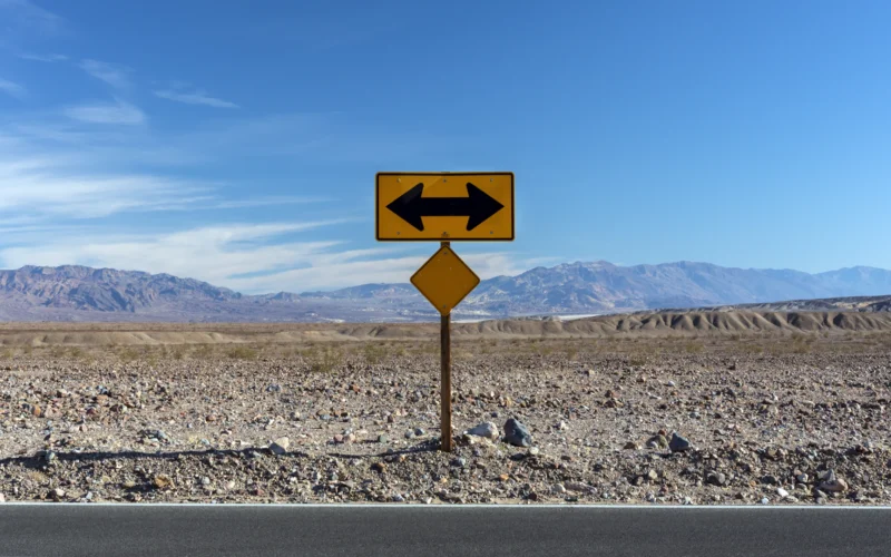 A road sign pointing in opposite directions in the desert