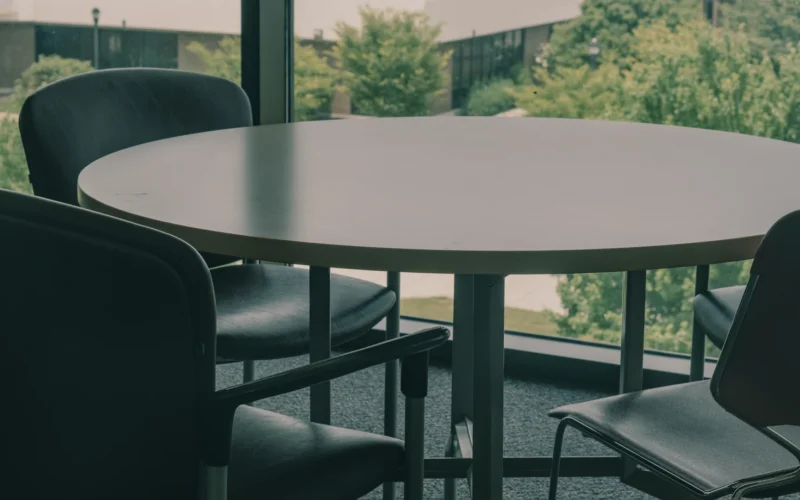 A table and chairs in front of a large window