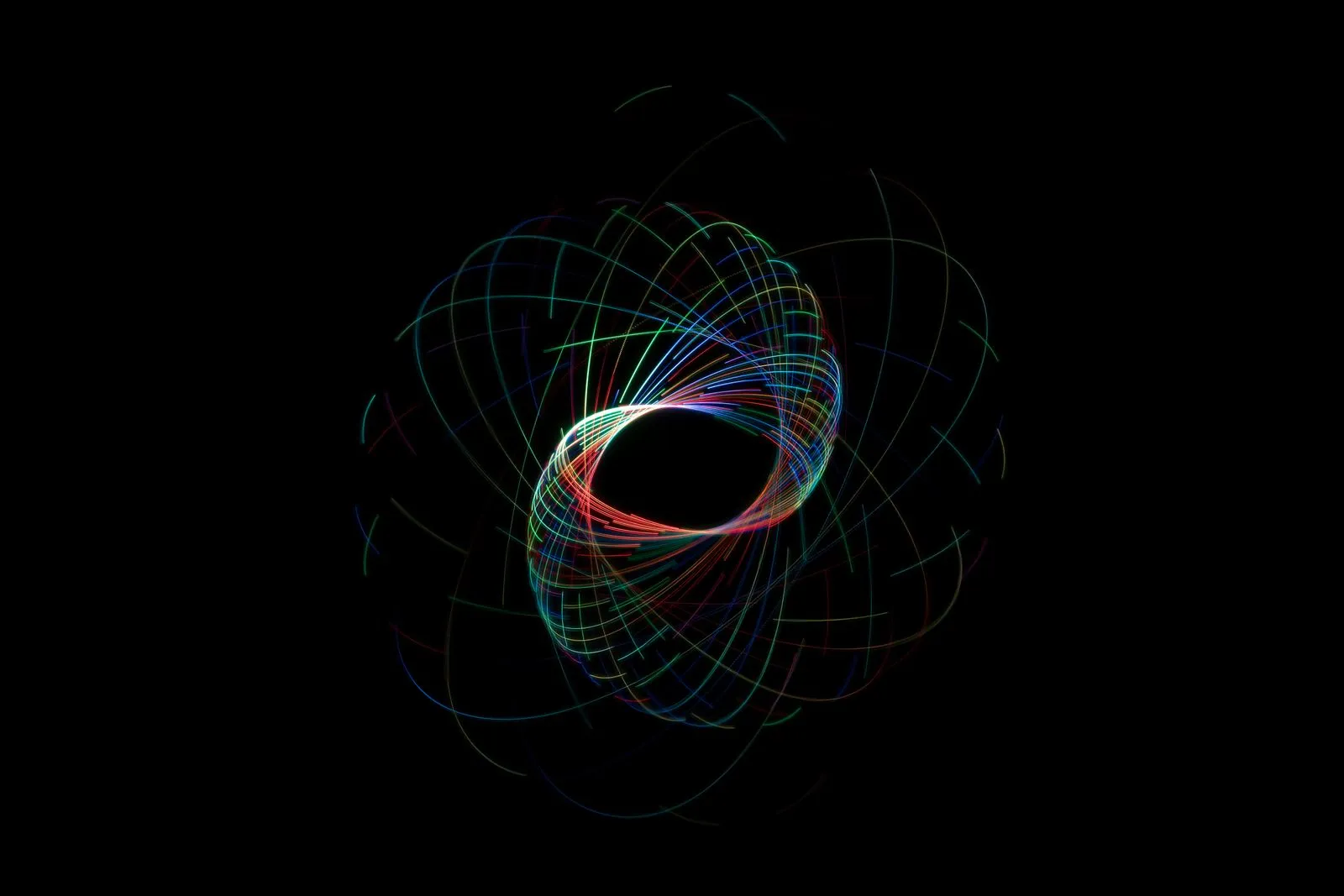 Coloured light trails looping on a black background, an abstract image of AI reasoning paths