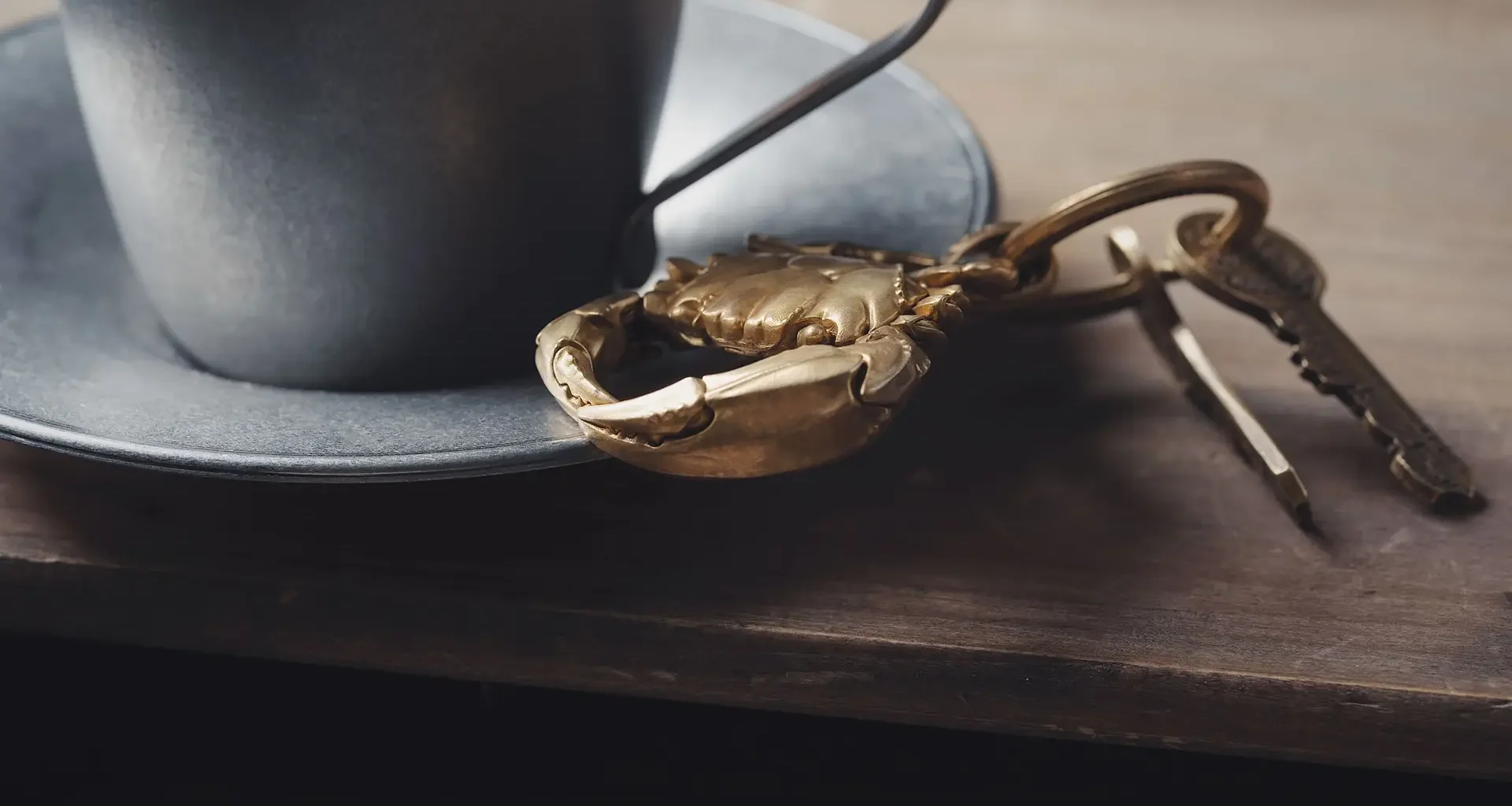Keys on a wooden table beside a cup, a reminder that third-party AI agents need their own access keys