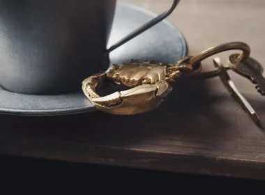 Keys on a wooden table beside a cup, a reminder that third-party AI agents need their own access keys