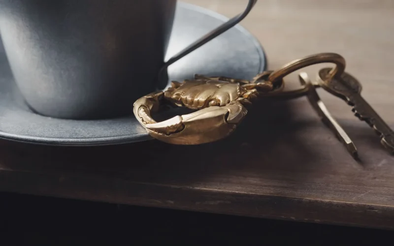 Keys on a wooden table beside a cup, a reminder that third-party AI agents need their own access keys