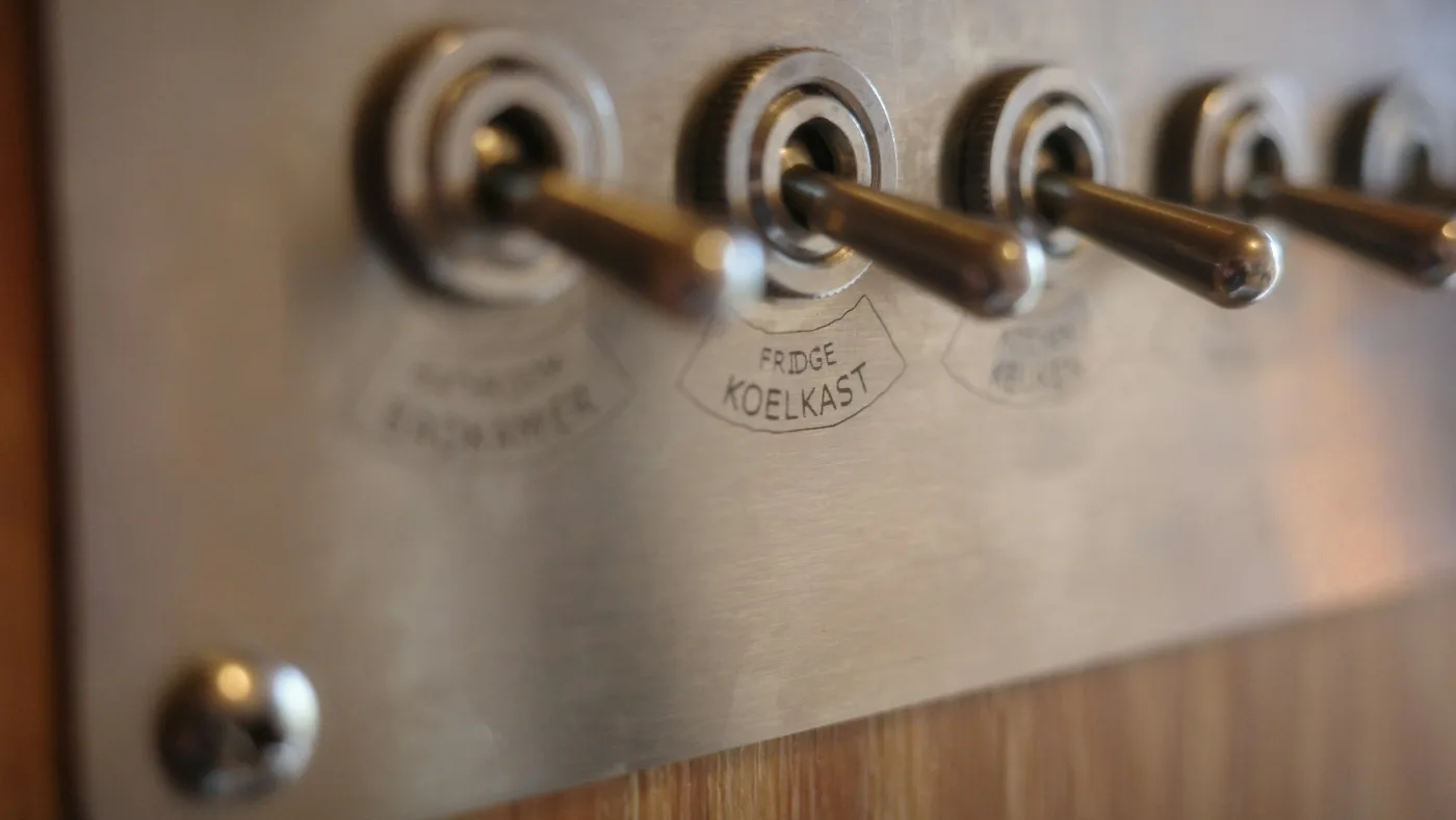 Row of vintage metal toggle switches mounted together.