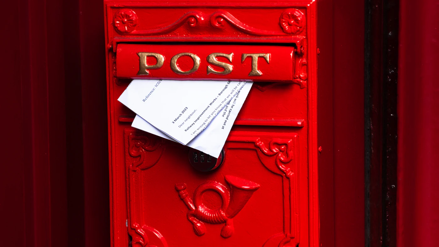 A red post box with a paper notice stuck to it