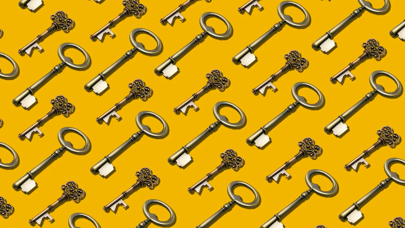 A bunch of metal keys spread across a bright yellow background