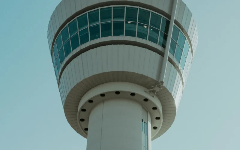 A tall white airport control tower against an open sky