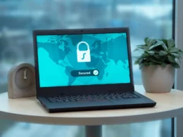 Laptop on a round table showing a padlock and the word secured on screen.