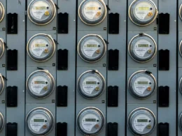 A black and white photograph of an electric utility meter on a wall