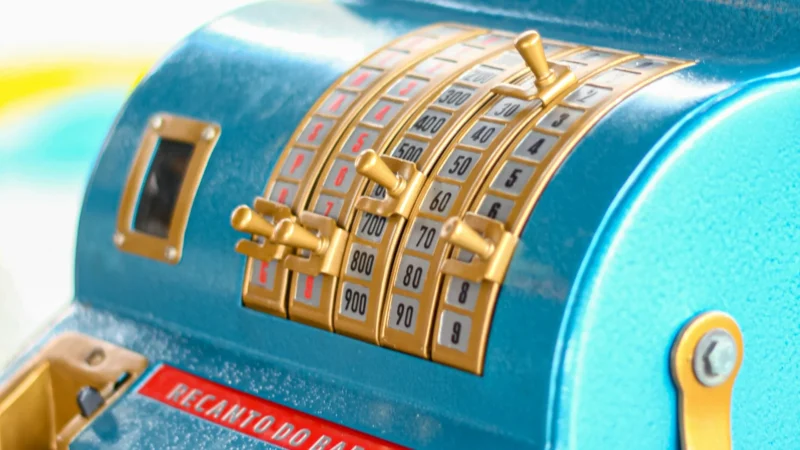 A blue cash register sitting on a shop counter