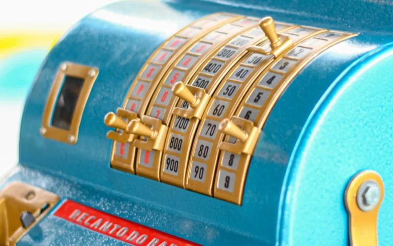 A blue cash register sitting on a shop counter