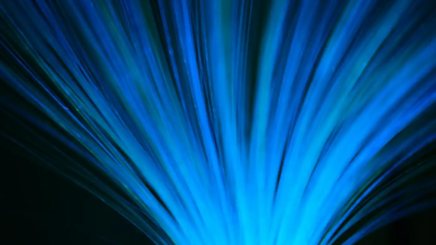 Blue fibre optic strands fanning out against a dark background, a stand-in for data Calgary AI startups send to AI models