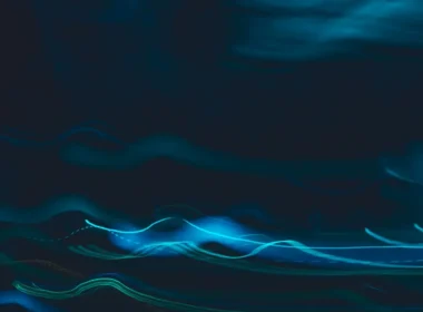 Blue light streaks curving across a dark background