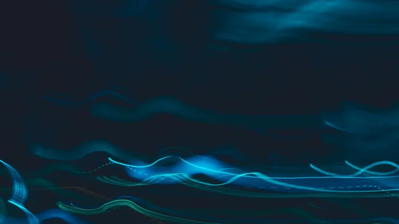 Blue light streaks curving across a dark background