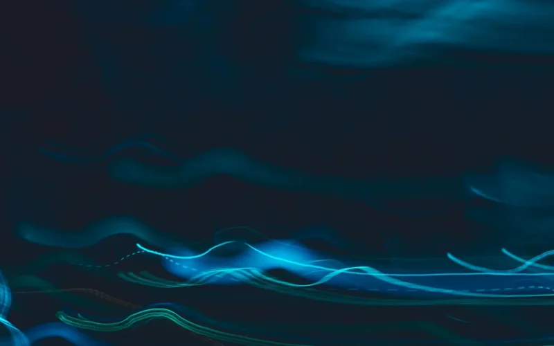 Blue light streaks curving across a dark background