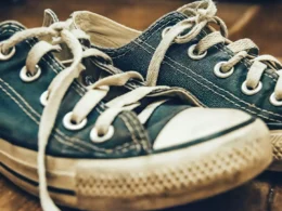 A pair of blue sneakers sitting on a wooden floor