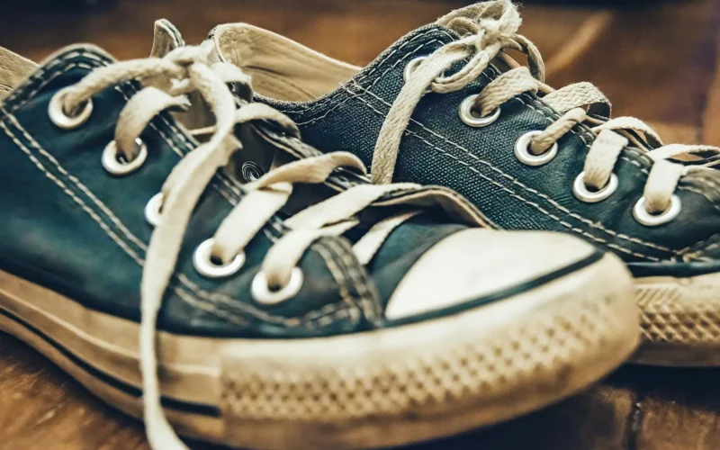 A pair of blue sneakers sitting on a wooden floor