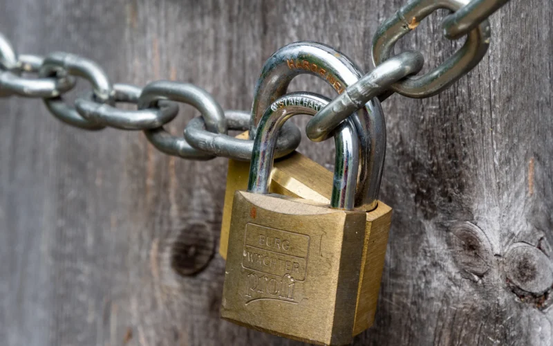 Brown padlock on brown wooden fence