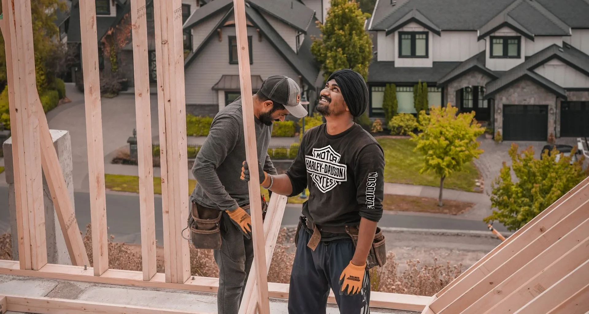 Two builders framing a wood house in a residential neighbourhood in the Vancouver area, BC