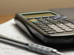 A calculator and a pen resting on a sheet of paper