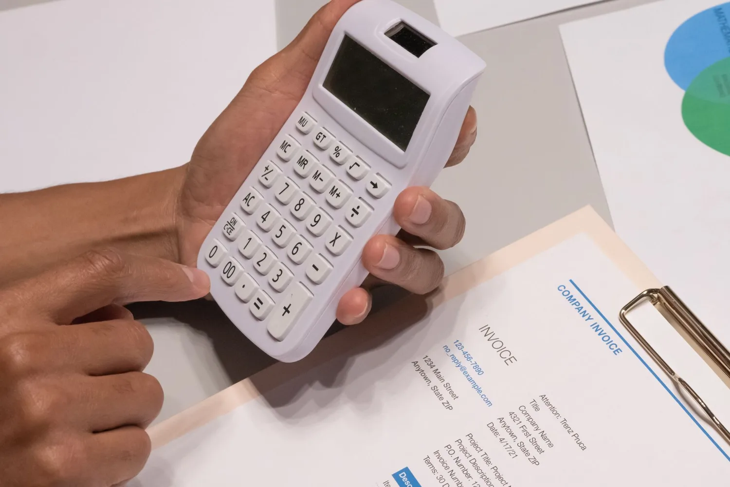 Hands using a calculator beside an invoice, checking Claude Sonnet 5.5 pricing against a monthly AI bill