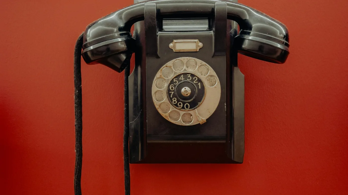 An old-fashioned telephone on a red wall