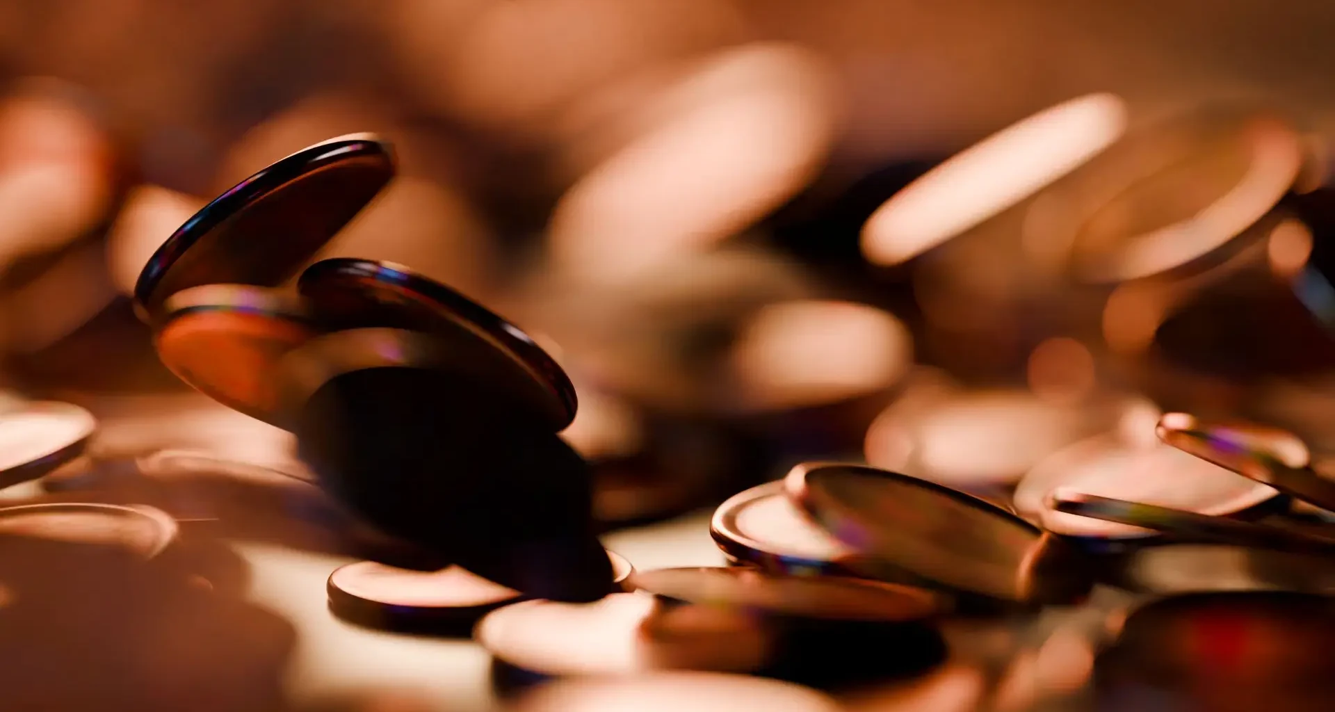 Copper coins scattered in warm low light, a stand-in for the Chamber AI Adoption Program grant split many ways