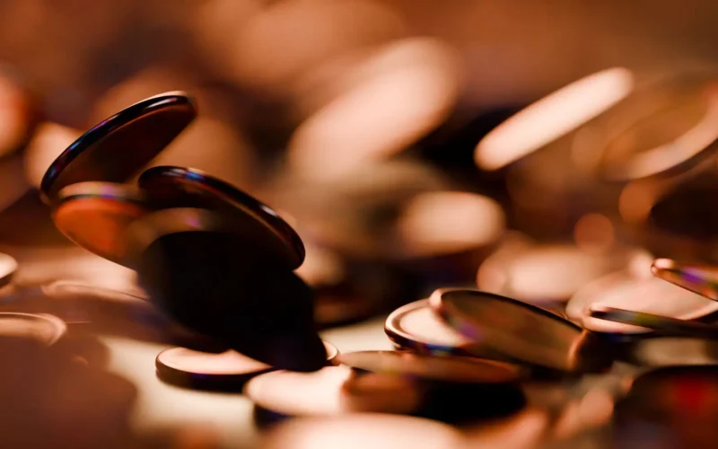 Copper coins scattered in warm low light, a stand-in for the Chamber AI Adoption Program grant split many ways