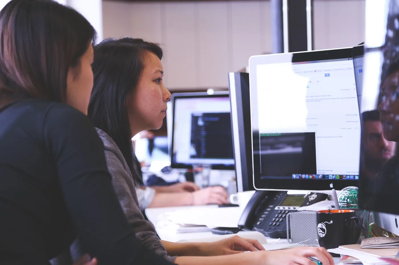 Claude for Google Workspace: two colleagues working together at a desktop computer in an open office.