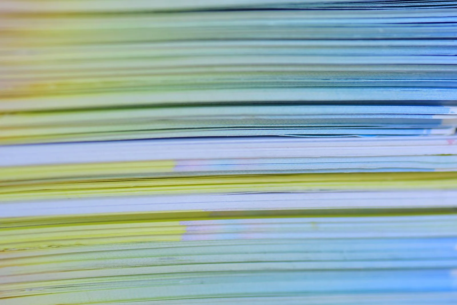 Close-up of a stack of pale green and blue paper, the kind of pile CRA scanned receipts are meant to replace
