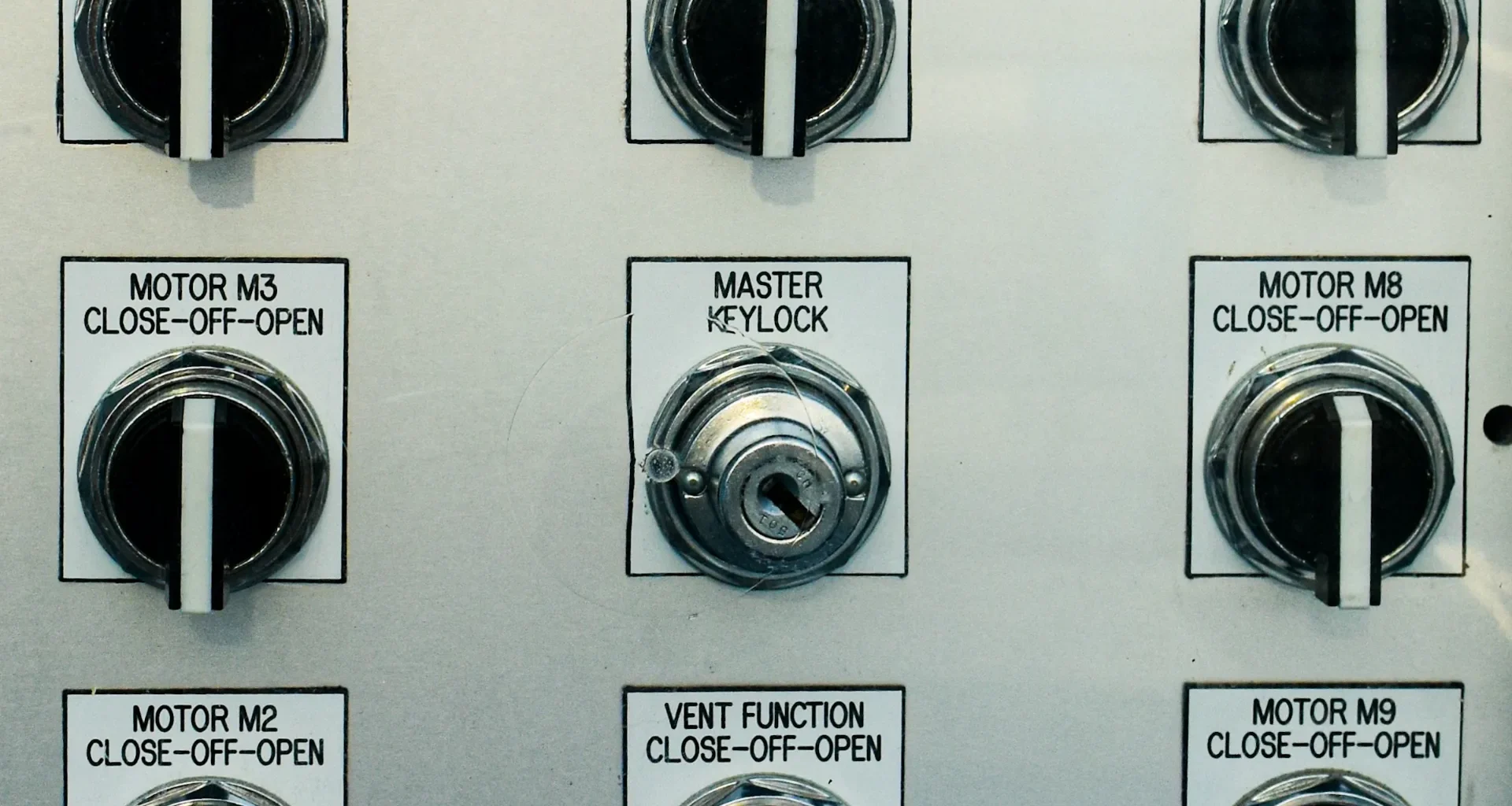 Control panel with several switches and a red emergency stop button