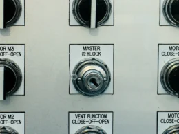 Control panel with several switches and a red emergency stop button.