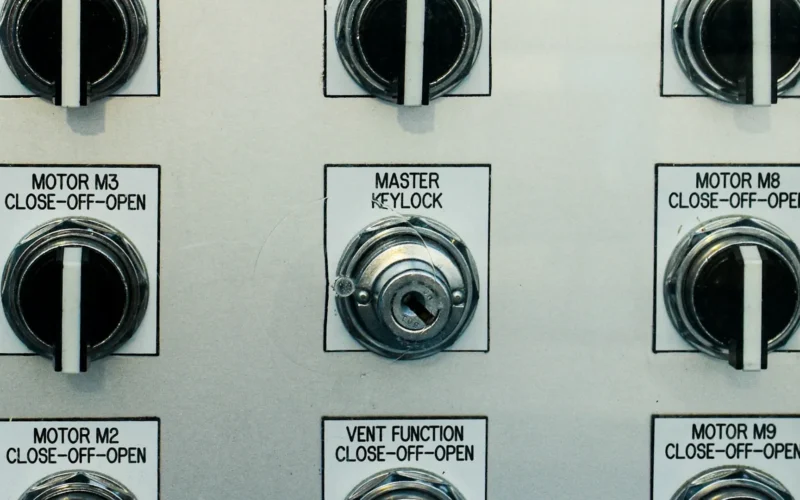 Control panel with several switches and a red emergency stop button