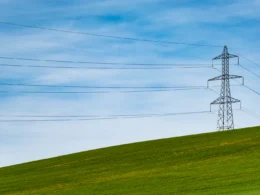 Electrical tower on grass field.