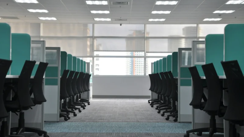 Empty black rolling chairs at office cubicles
