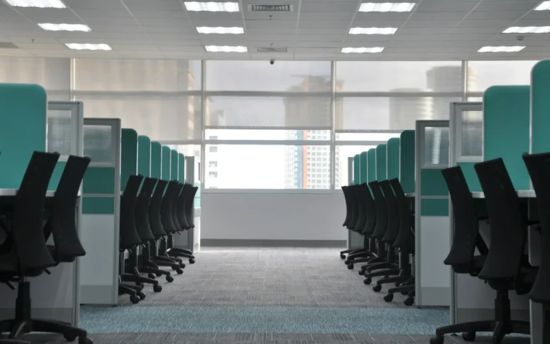 Empty black rolling chairs at office cubicles