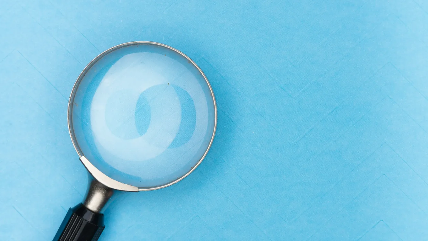 FTC AI investigation: magnifying glass resting on a white table.