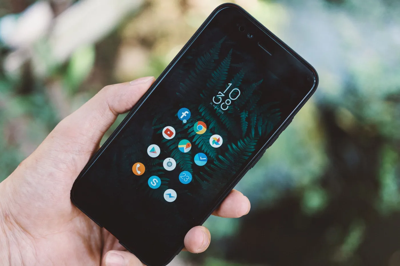 GPT-6 Intelligent UI: hand holding a smartphone with a grid of app icons on the screen.