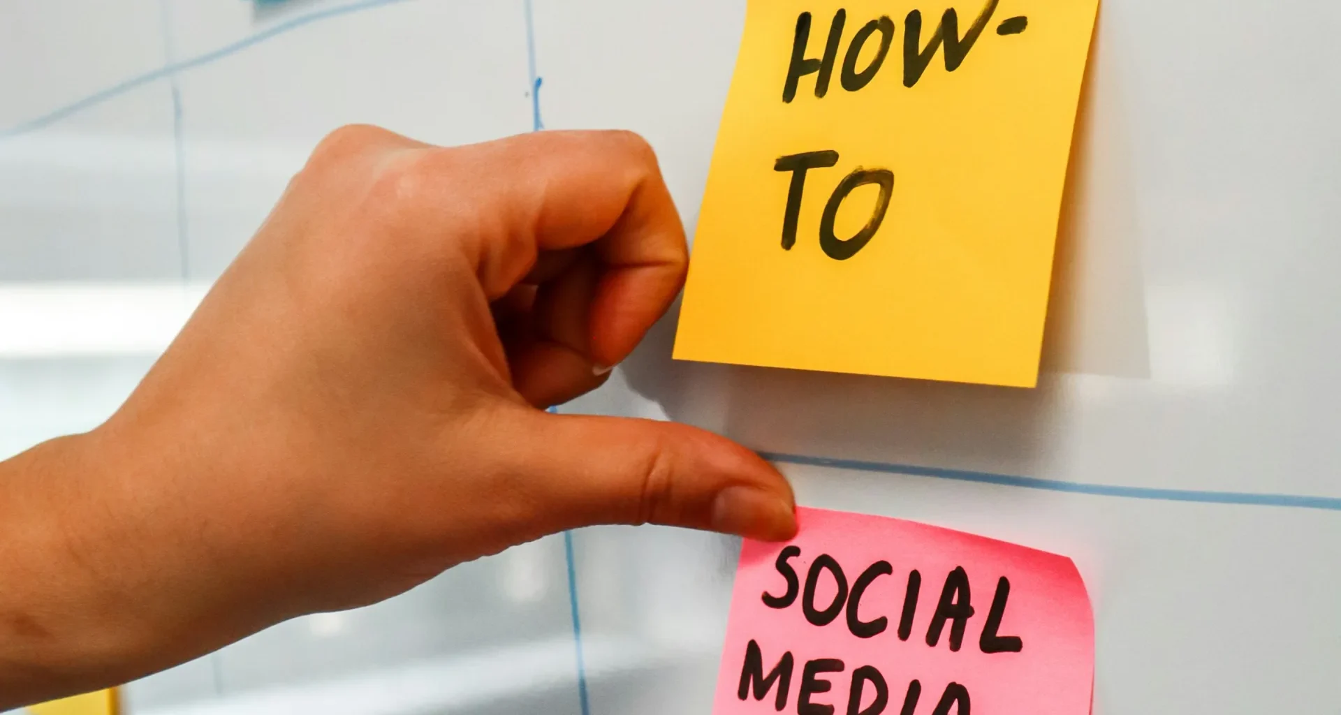 A hand pointing to sticky notes on a bulletin board